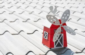 Closeup on a model barn with a windmill on top of a roof