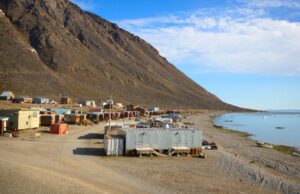 Sustainable green homes, buildings, and mountains along the coastline in Nunavut