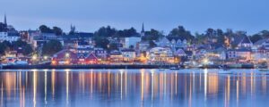 The Halifax, Nova Scotia waterfront at dusk, with lights from the buildings and houses reflecting off the water