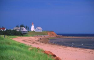 Prince Edward Island coastline with several homes and a lighthouse in the distance