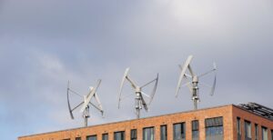 Three vertical axis small wind turbines atop an apartment building