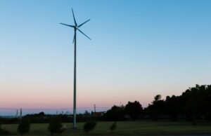 The silhouette of a five-blade small wind turbine in a backyard at sunset