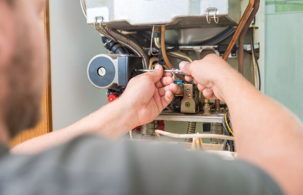 A homeowner makes an adjustment to his natural gas furnace