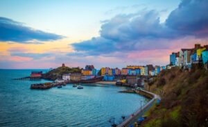 The waterfront of a sleepy Welsh town at sunset, with various homes and bordering the ocean