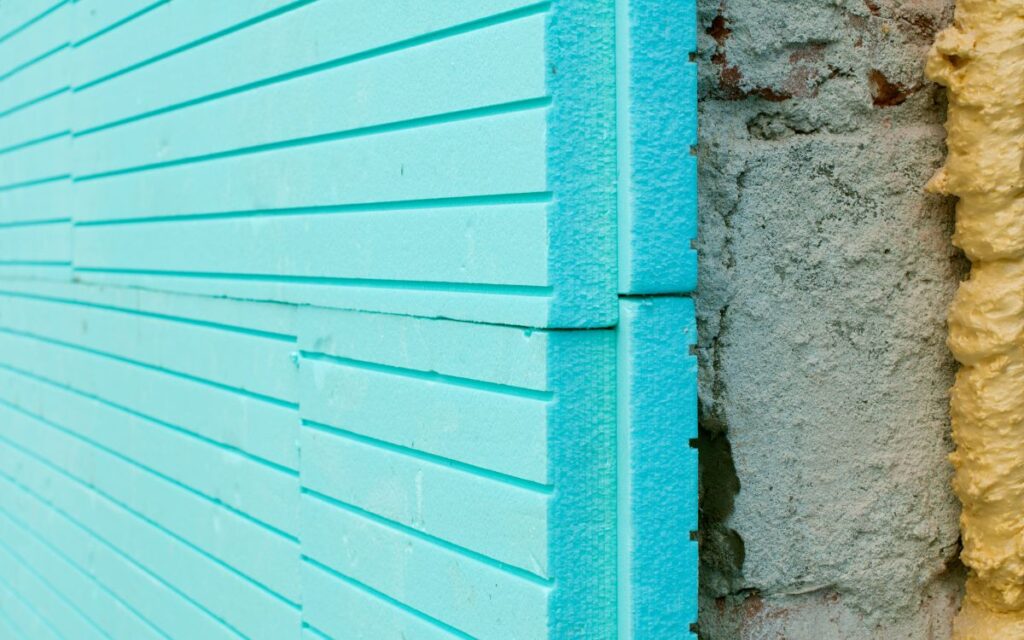 Panels of blue thermal foam insulation installed over a concrete exterior wall
