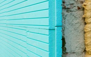 Panels of blue thermal foam insulation installed over a concrete exterior wall
