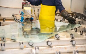 A sheet of tempered hurricane window glass is fabricated in a factory