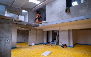 A radiant floor heating installation being done in a large open space in a building.