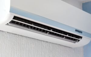 Closeup on a mini-split air handler unit on the wall in the corner of a room