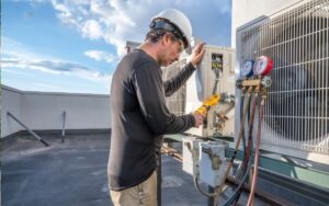 A technician on a roof measures a mini-split's energy consumption