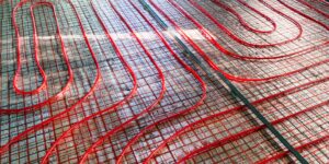 Red radiant floor heating pipes set out in preparation for floor to be poured.