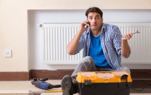 A homeowner with a puzzled look on his cell phone ponders how to install a radiant wall heating system