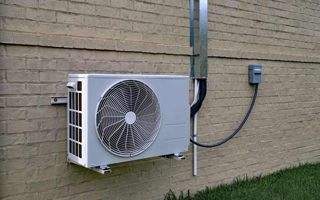 The external compressor unit of a mini-split mounted on home's exterior wall