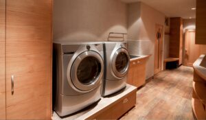 Two Heat Pump Dryers on a platform against a wall in a room of a home