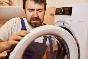 A homeowner looks quizzically at the door of his dryer