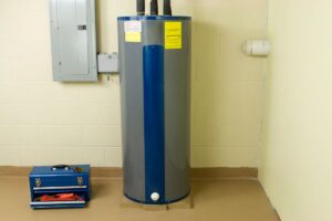A water Heater in a basement with water heater insulation attached to the pipes on top
