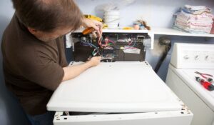 A homeowner adjust the water line on his tumble dryer
