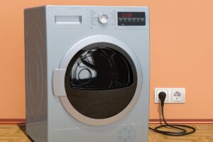 Closeup on a heat pump dryer against a peach-colored wall in a home
