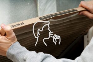 a person pulling a dirty air filter out of the home HVAC system, with a symbol of a face outline coughing in the middle