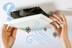 a bathroom fan being installed showing two hands holding it up