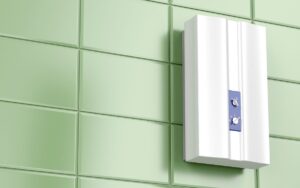 A tankless water heater mounted on a green tile wall