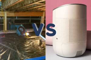 An illuminated crawl space with a vapor barrier installed on the ground at left and a dehumidifier to the right