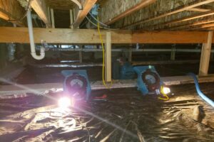 An illuminated encapsulated crawl space with a vapor barrier installed on the ground