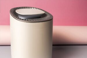 a home dehumidifier on the ground in front of a pink wall