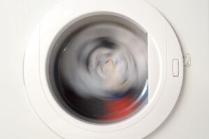 Closeup on the window of a heat pump dryer with a spin cycle in progress