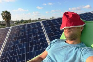 A homeowner napping in the sun in front of an array of passive solar panels