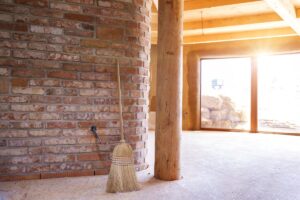 The interior of a passive solar home with the sun shining in brightly through a floor-to-ceiling set of windows