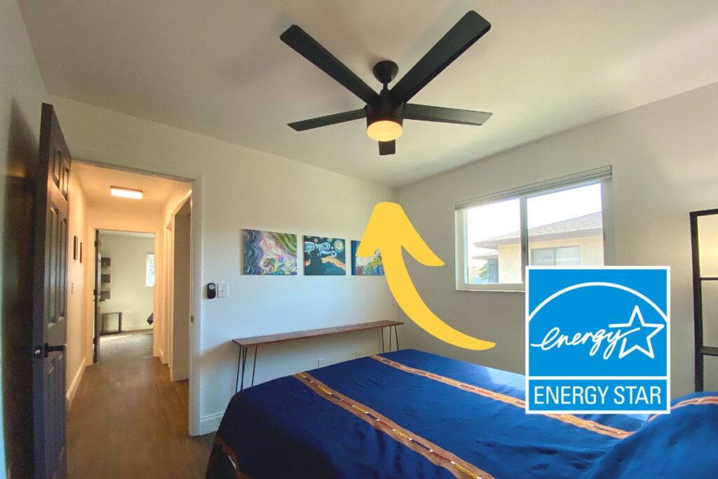 a bedroom with a black energy star ceiling fan installed in the middle of the ceiling