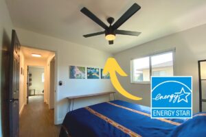 a bedroom with a black energy star ceiling fan installed in the middle of the ceiling