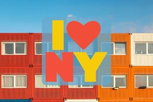 a bunch of stacked container homes with white windows and an I Love NY graphic in the middle