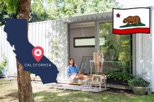 A homeowner sitting in the entryway to her container home in the California wilderness