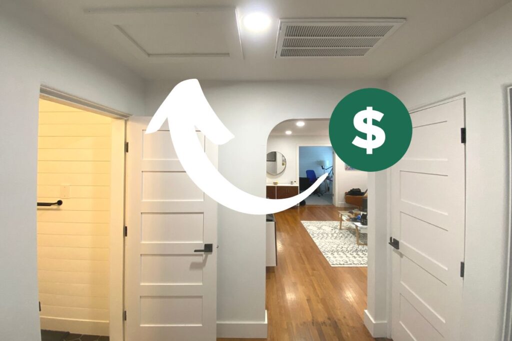 a picture of a hallway in a house with a white graphic arrow and a dollar sign pointing to the attic hatch