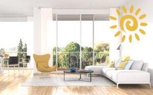 a bright living room with a yellow chair and white couch in it, with tons of natural light coming in through the windows and sliding doors