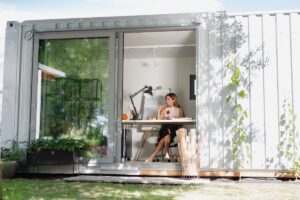 A homeowner sitting at a desk in her shipping container home