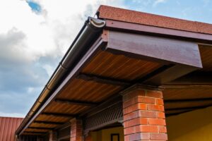 Closeup on a corner of a front porch, and the roof overhangs in particular