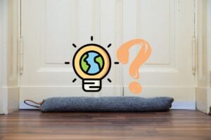Photo of a white painted door with a blue draft door stopper underneath with an energy-efficiency graphic in the center