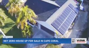 an aerial view of a solar netzero white home with a grey roof