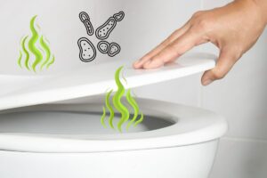 Closeup on a homeowners hand lifting the top part of a toilet set, with graphics depicting odor and bacteria arising