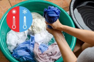 A woman wringing out an article of clothing as she's hand-washing clothes in warm water