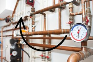 water pipes and a pressure gauge with a graphic of an arrow transposed above the image